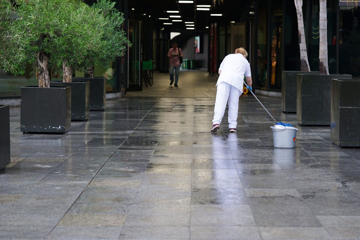 Cleaner mopping a commercial corridor floor