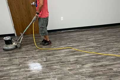 Technician buffing a hardwood floor with a rotary machine